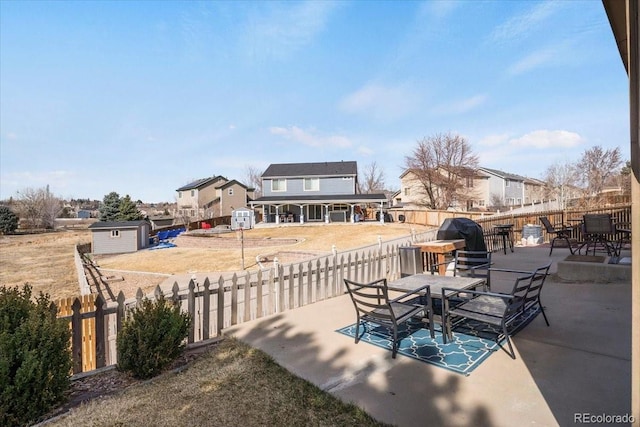 view of patio / terrace featuring an outdoor structure, fence private yard, a shed, and a grill