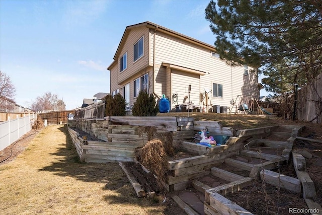 back of property featuring a lawn and a fenced backyard