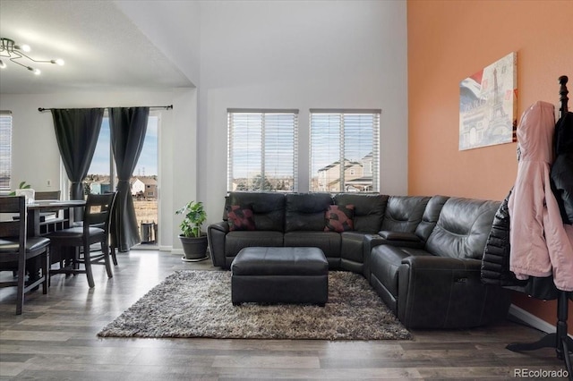 living room featuring a towering ceiling and wood finished floors