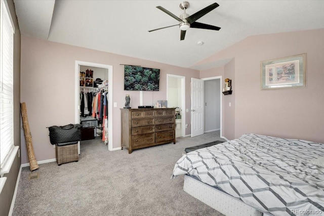 carpeted bedroom featuring a spacious closet, baseboards, vaulted ceiling, a closet, and a ceiling fan