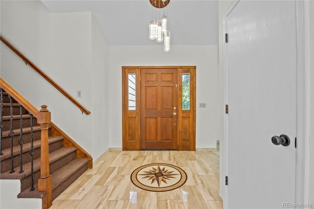 8725 Meadowlark Cir, Highlands Ranch, CO 80126 - entryway featuring stairway, a chandelier, and wood finished floors