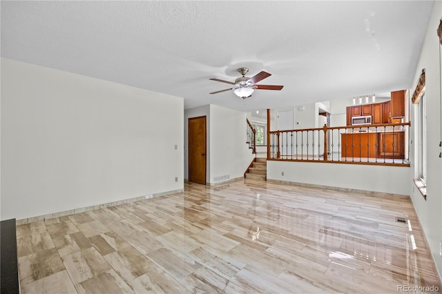 8725 Meadowlark Cir, Highlands Ranch, CO 80126 - unfurnished living room featuring ceiling fan and stairway