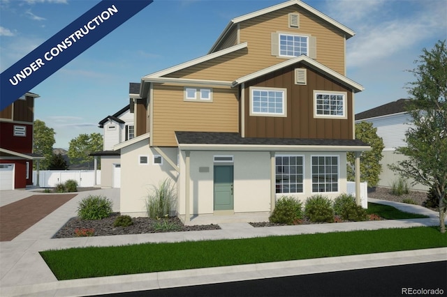 traditional home featuring board and batten siding, an attached garage, decorative driveway, and fence