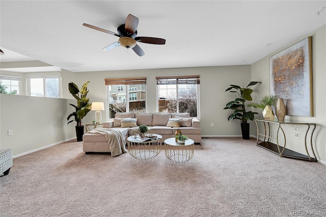 carpeted living area featuring a ceiling fan and baseboards