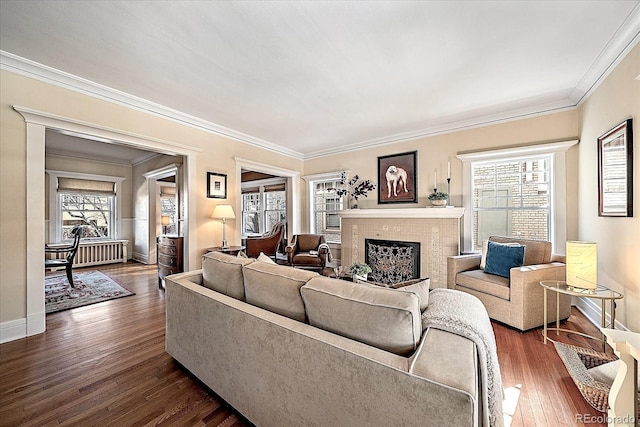 living room with crown molding, dark wood-type flooring, and a high end fireplace