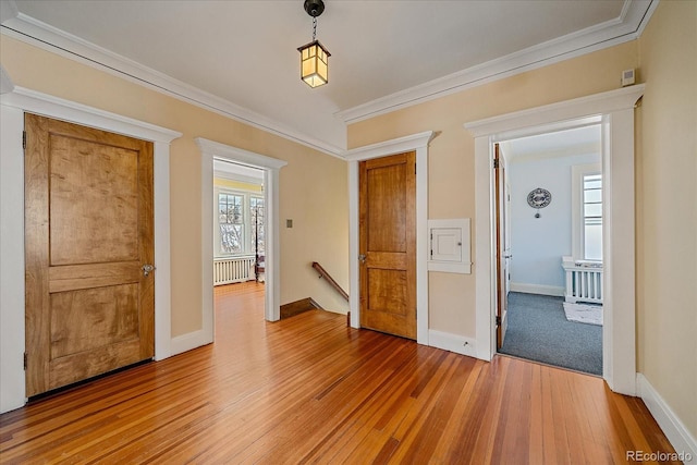 interior space featuring crown molding, radiator heating unit, and light wood-type flooring