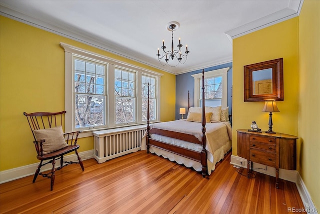 bedroom with crown molding, radiator heating unit, a chandelier, and light hardwood / wood-style floors