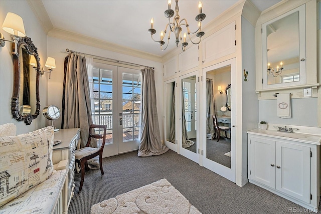 sitting room with french doors, ornamental molding, an inviting chandelier, and dark colored carpet