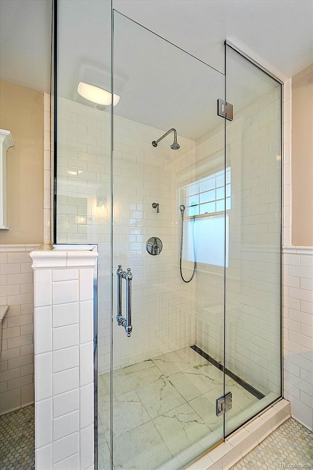 bathroom with walk in shower, tile patterned flooring, and tile walls