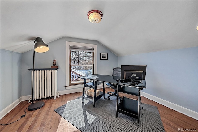 office featuring radiator, vaulted ceiling, and hardwood / wood-style floors