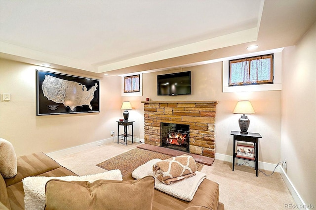 carpeted living room featuring a stone fireplace