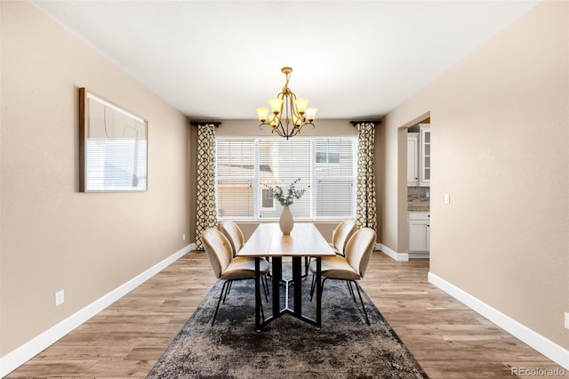 dining area featuring light hardwood / wood-style flooring and a chandelier