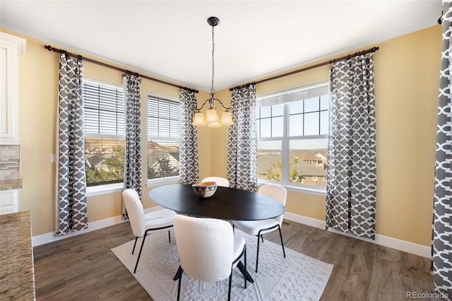 dining space with a notable chandelier and dark wood-type flooring