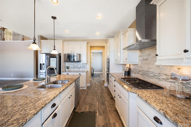 kitchen featuring pendant lighting, dark wood-type flooring, wall chimney range hood, sink, and appliances with stainless steel finishes