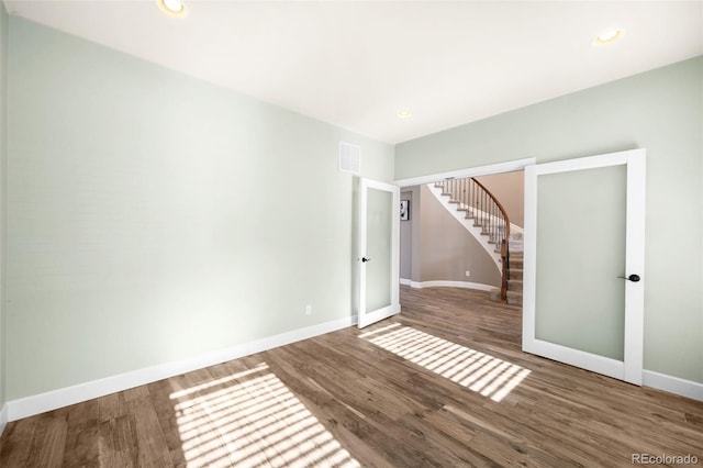 unfurnished room with hardwood / wood-style flooring