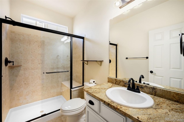 bathroom featuring vanity, an enclosed shower, and toilet