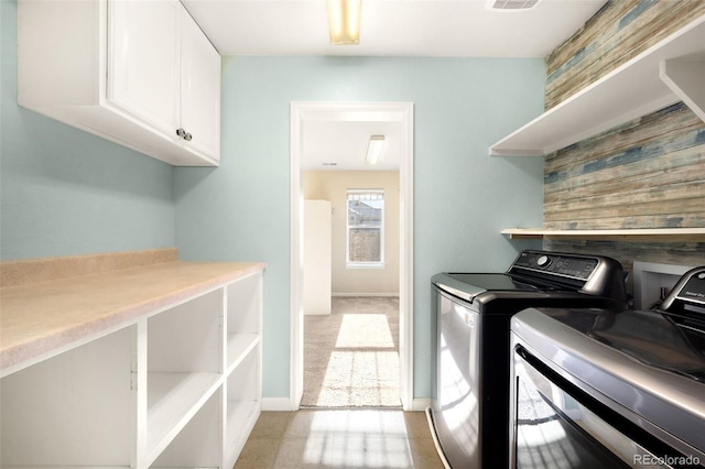 laundry room with washer and dryer and cabinets