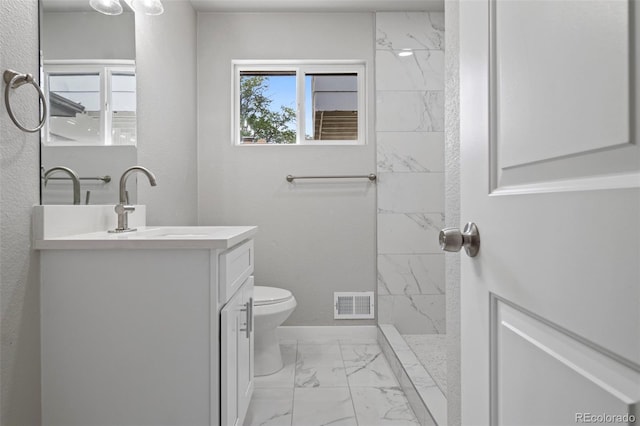 bathroom with walk in shower, vanity, and toilet