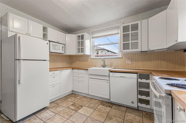 2515 Ames St, Edgewater, CO 80214 - kitchen featuring white appliances, a sink, wooden walls, white cabinetry, and open shelves