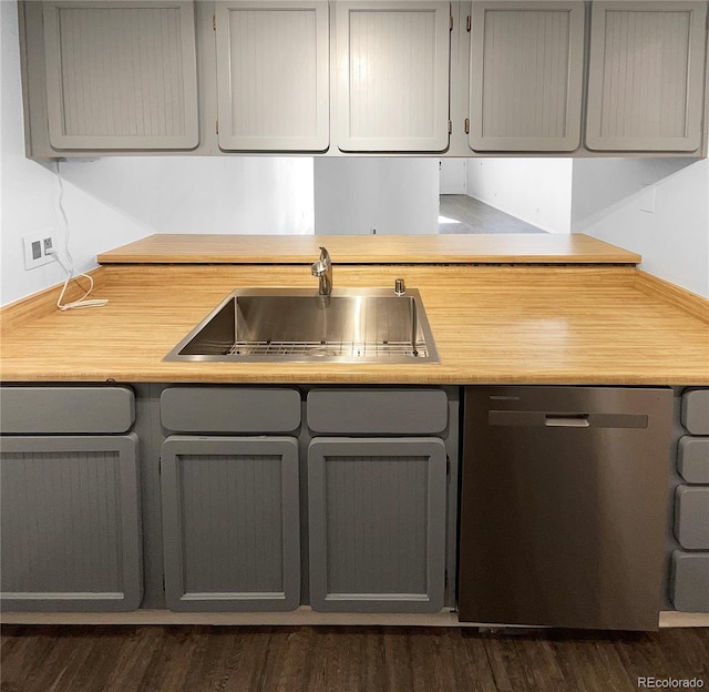 kitchen with stainless steel dishwasher, dark hardwood / wood-style floors, gray cabinetry, and sink