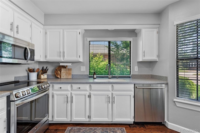 7968 S Trenton St, Centennial, CO 80112 - kitchen featuring appliances with stainless steel finishes, white cabinetry, light countertops, and dark wood-type flooring