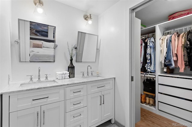 7968 S Trenton St, Centennial, CO 80112 - bathroom with double vanity, a spacious closet, and wood finished floors