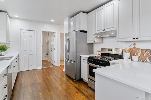 4003 Federal Blvd, Denver, CO 80211 - kitchen featuring under cabinet range hood, appliances with stainless steel finishes, white cabinets, dark wood finished floors, and recessed lighting