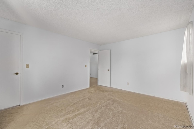 carpeted empty room featuring a textured ceiling