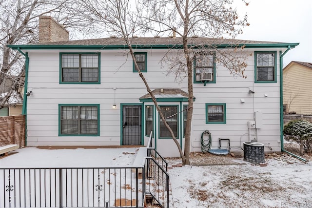 snow covered house featuring central AC