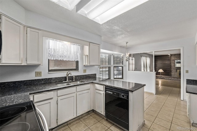 kitchen with a sink, light tile patterned floors, black appliances, a peninsula, and a notable chandelier