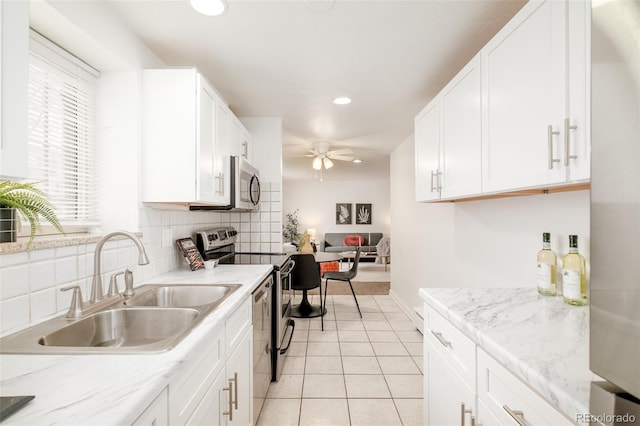 kitchen with ceiling fan, sink, stainless steel appliances, and white cabinets