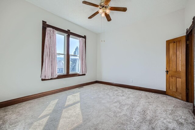 carpeted empty room with a textured ceiling and ceiling fan