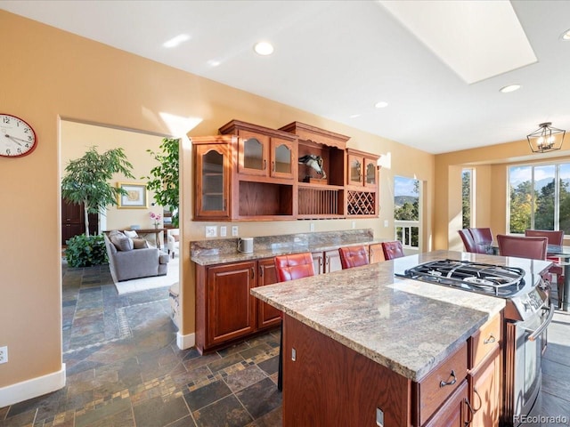 kitchen with stainless steel range oven, a center island, and a skylight