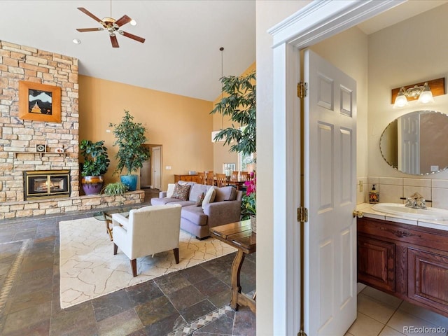 living room with ceiling fan, a fireplace, and sink