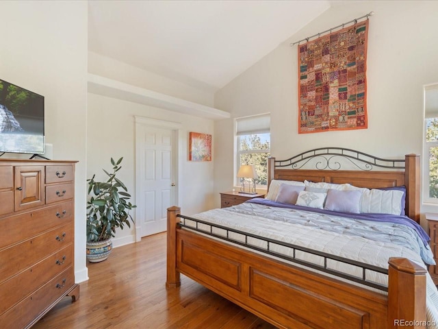 bedroom featuring high vaulted ceiling and light hardwood / wood-style floors