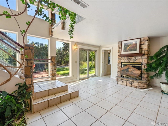 unfurnished sunroom with a healthy amount of sunlight and a stone fireplace