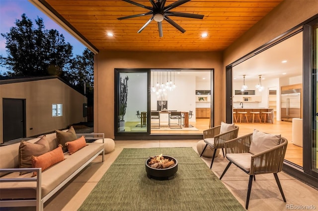 view of patio featuring an outdoor living space with a fire pit and a ceiling fan