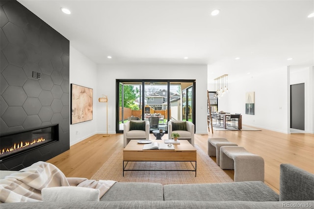 living area with wood finished floors, recessed lighting, a fireplace, and baseboards