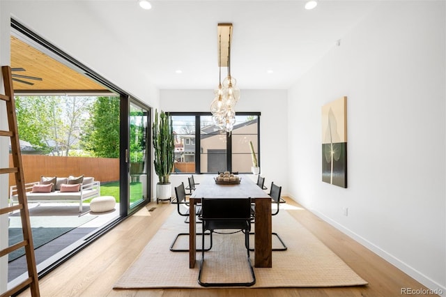 dining area with light wood finished floors, recessed lighting, a chandelier, and baseboards