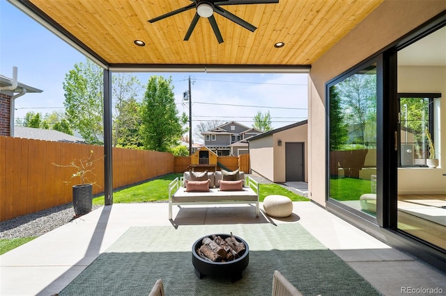 view of patio / terrace with a fenced backyard, a ceiling fan, an outdoor living space, and an outdoor structure