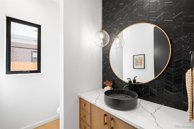 bathroom featuring vanity, baseboards, and toilet