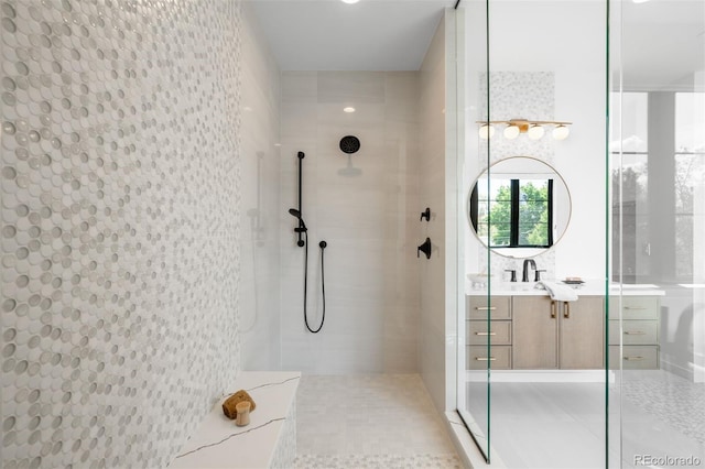full bathroom with tiled shower, vanity, and tile patterned floors