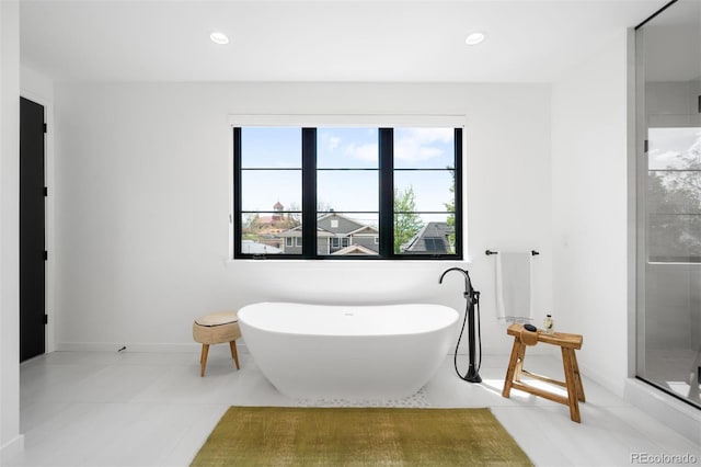 full bath with a freestanding bath, a shower stall, tile patterned flooring, recessed lighting, and baseboards