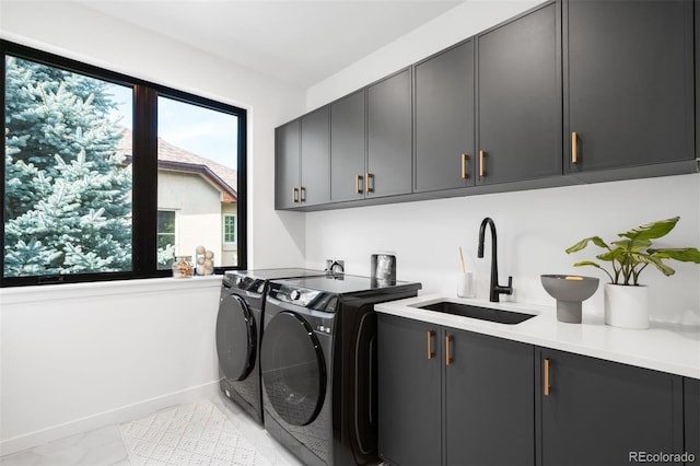 washroom featuring cabinet space, washing machine and clothes dryer, baseboards, and light marble finish floors