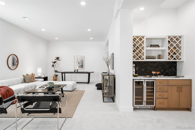 living area featuring wine cooler, bar with sink, recessed lighting, light colored carpet, and baseboards