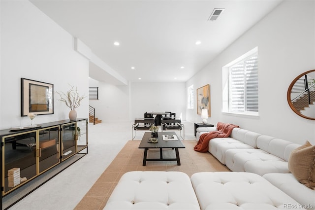 living area featuring light colored carpet and recessed lighting