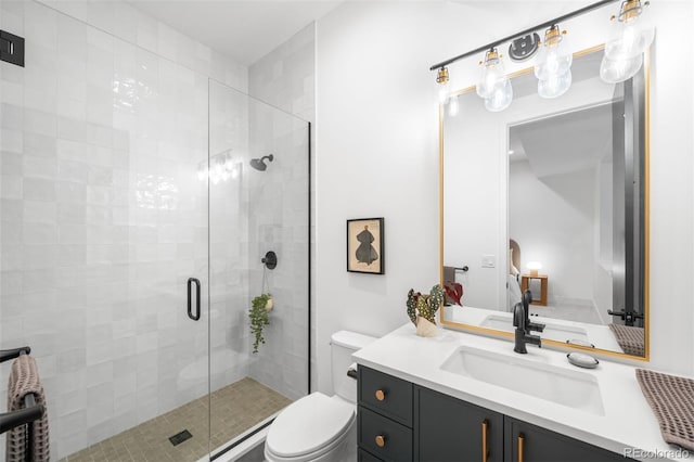 full bathroom featuring toilet, a shower stall, and vanity
