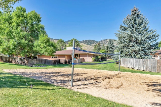 view of yard with fence, volleyball court, and a mountain view