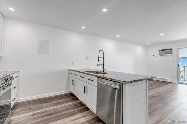 kitchen featuring recessed lighting, stainless steel appliances, a peninsula, a sink, and light wood-type flooring