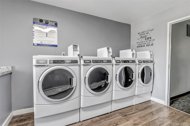 common laundry area with washer and dryer, visible vents, baseboards, and wood finished floors